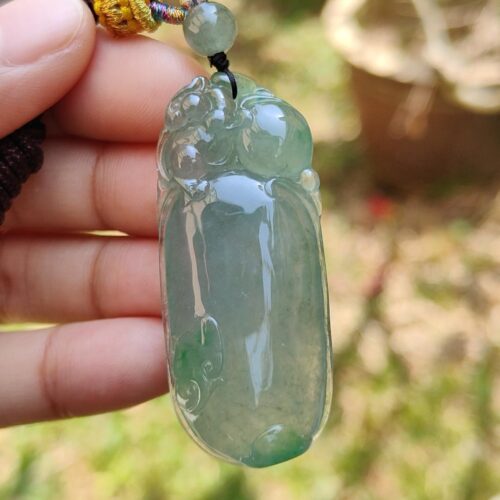 Una mano sosteniendo un colgante de jade.