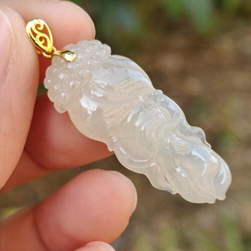 Una mano sosteniendo un colgante de jade.