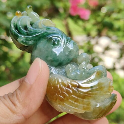 a hand holding a jade sculpture