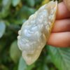 Una mano sosteniendo un colgante de jade.