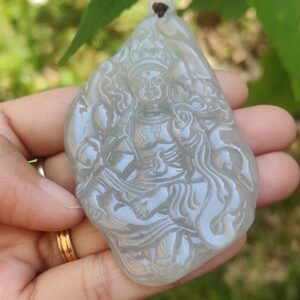 Una mano sosteniendo un colgante de jade.