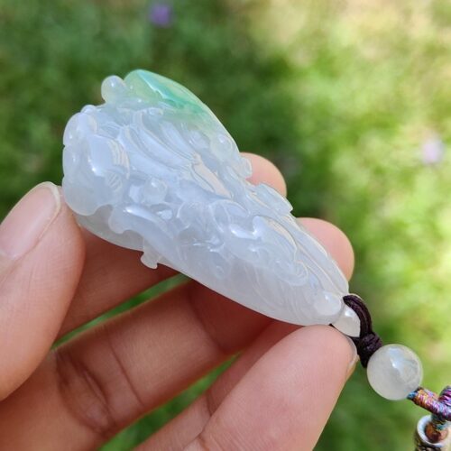 Una mano sosteniendo un colgante de jade.