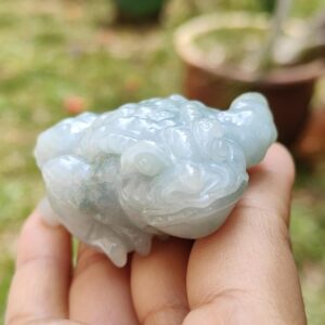 Una mano sosteniendo una pequeña piedra blanca.