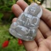 a hand holding a jade pendant