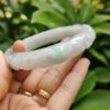 a hand holding a jade bracelet