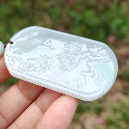 a hand holding a white pendant