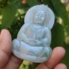 एक हाथ में जेड बुद्ध की मूर्ति पकड़े हुए