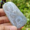 Una mano sosteniendo un colgante de jade.