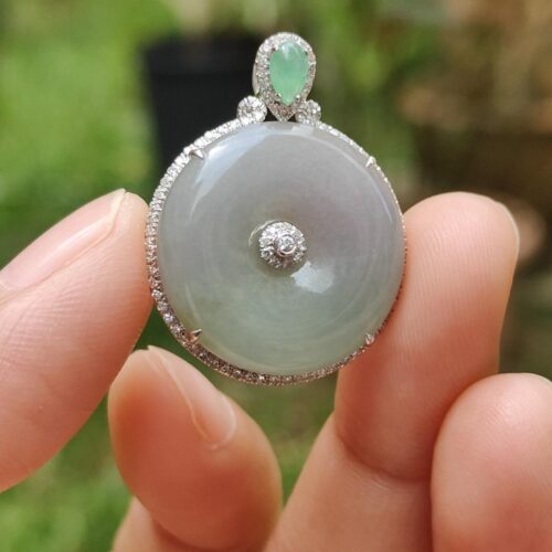 Una mano sosteniendo un colgante de jade.