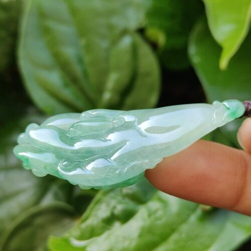 eine Hand, die ein Jadeobjekt hält