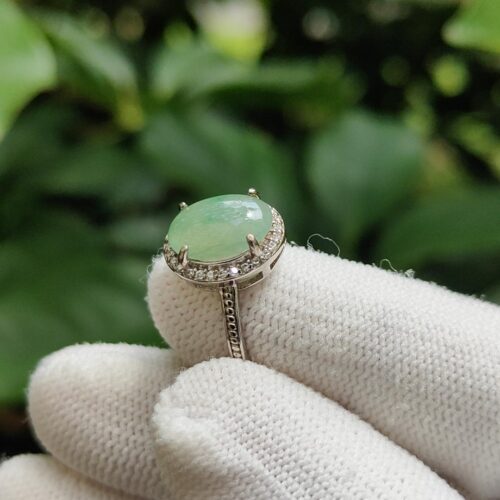 a hand wearing white gloves with a ring on it