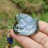 a hand holding a jade frog