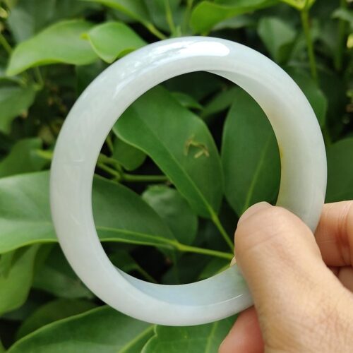 a hand holding a white bracelet