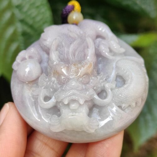 Una mano sosteniendo un colgante de piedra.