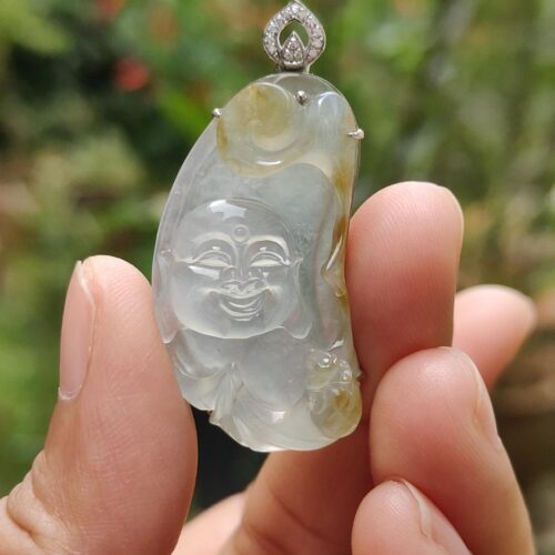 a hand holding a jade pendant