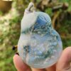 Una mano sosteniendo un colgante de jade.