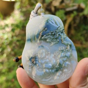 Una mano sosteniendo un colgante de jade.