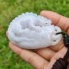 Una mano sosteniendo un colgante de jade.