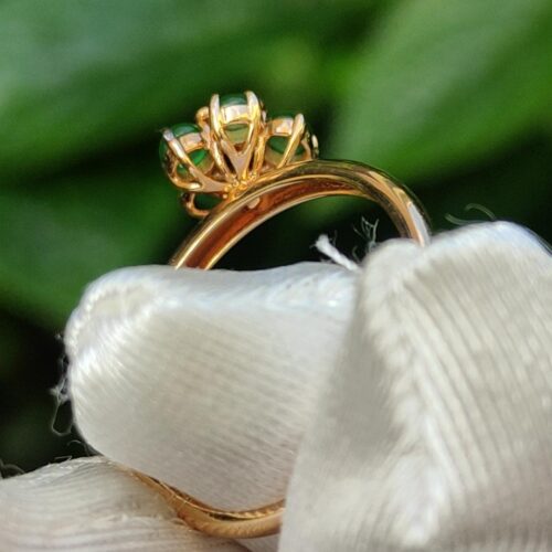 a gold ring with a green stone in it