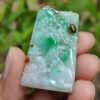 a hand holding a jade object