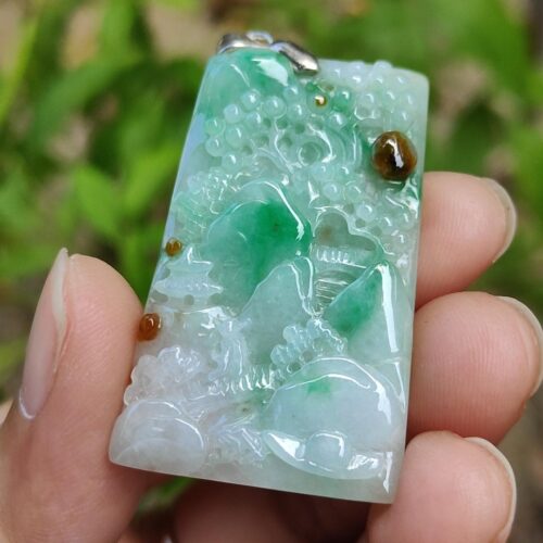 a hand holding a jade object