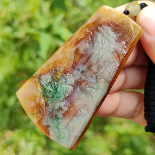 Una mano sosteniendo un colgante de piedra.