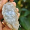 Una mano sosteniendo un colgante de jade.