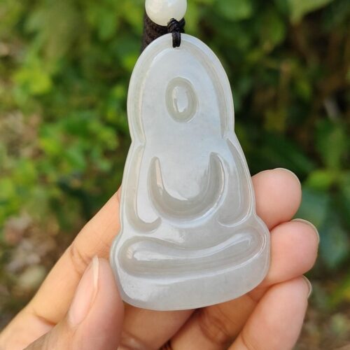 Una mano sosteniendo un colgante de jade.