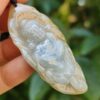Una mano sosteniendo un colgante de jade.