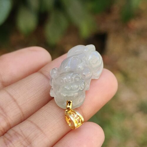 Una mano sosteniendo un colgante de jade.