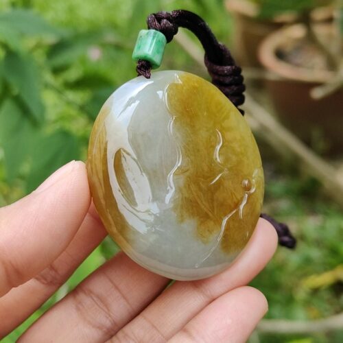 a hand holding a stone pendant