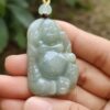 Una mano sosteniendo un colgante de jade.