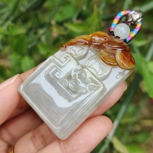 एक हाथ में जेड पेंडेंट थामे हुए