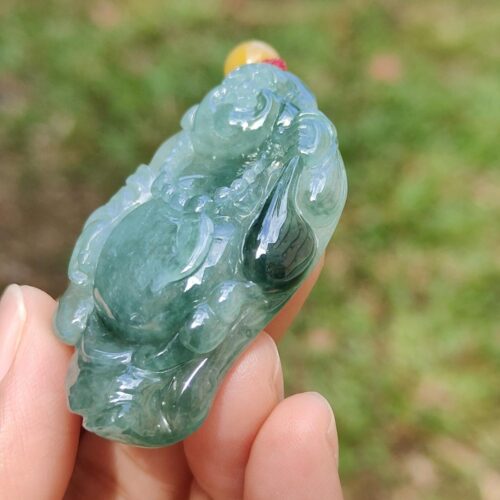a hand holding a jade object