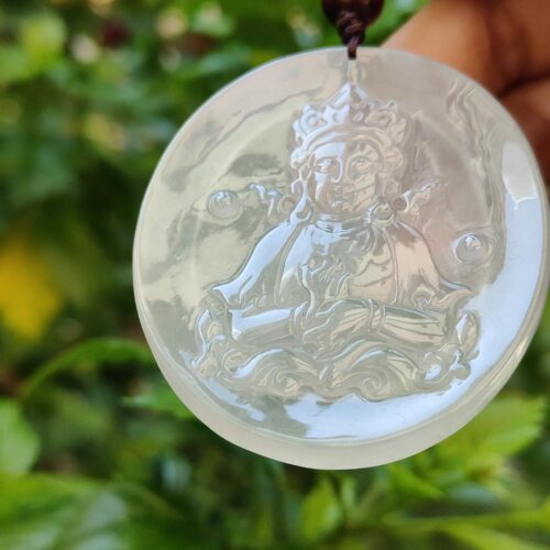 a hand holding a round white pendant