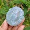 Una mano sosteniendo un colgante de jade.