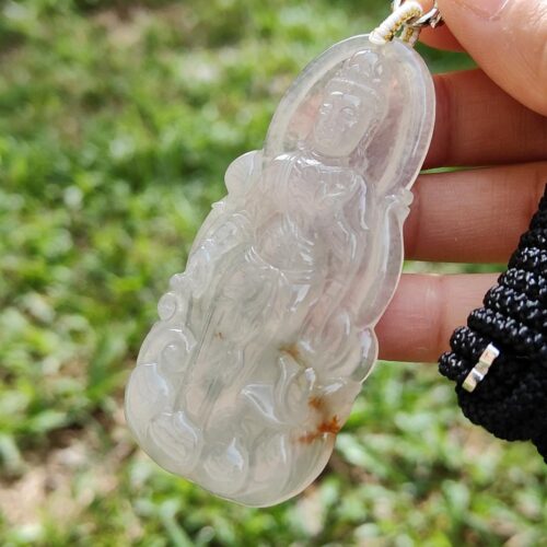 एक हाथ में जेड पेंडेंट थामे हुए