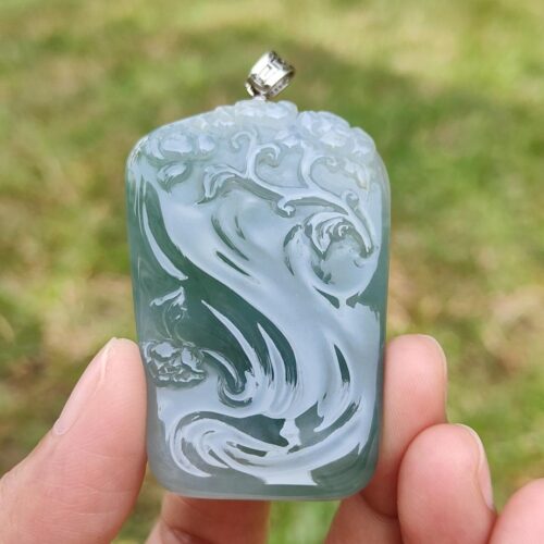 a hand holding a blue pendant