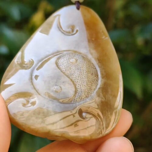 a hand holding a stone pendant