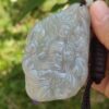 Una mano sosteniendo un colgante de jade.