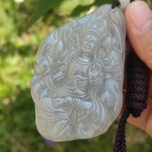 Una mano sosteniendo un colgante de jade.