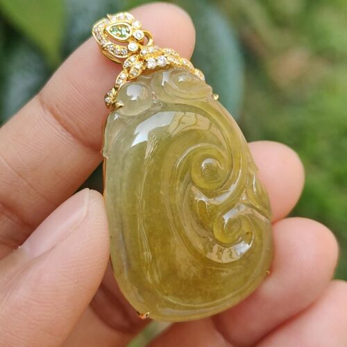 a hand holding a jade pendant