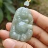 Una mano sosteniendo un colgante de jade.