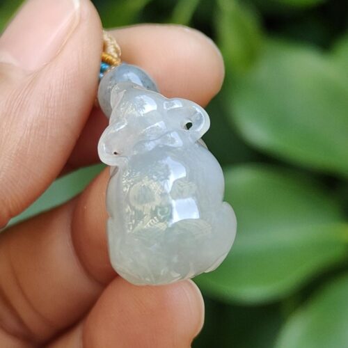 a hand holding a jade pendant