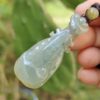 翡翠のペンダントを持つ手