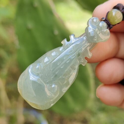 翡翠のペンダントを持つ手