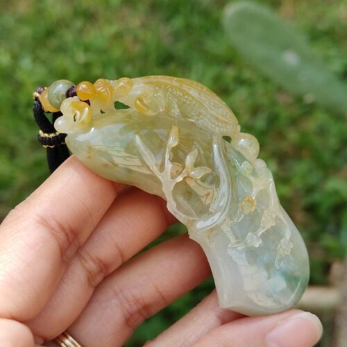 Una mano sosteniendo un colgante de jade.