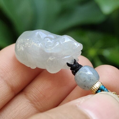 a hand holding a jade bead