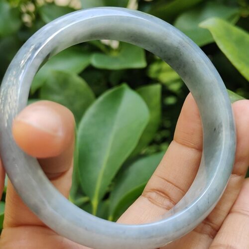 a hand holding a round stone ring