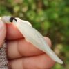 a hand holding a white bead